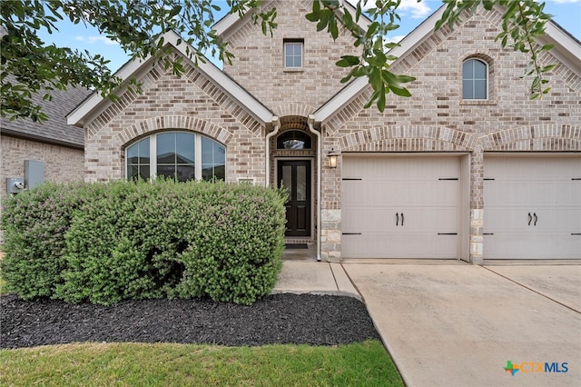 646 Arroyo Loma, New Braunfels, TX 78130 - french country style house with concrete driveway, stone siding, a garage, and brick siding