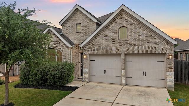 646 Arroyo Loma, New Braunfels, TX 78130 - french country home featuring concrete driveway, stone siding, brick siding, and roof with shingles