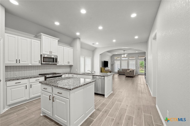 646 Arroyo Loma, New Braunfels, TX 78130 - kitchen featuring stainless steel appliances, a kitchen island, a sink, arched walkways, and open floor plan