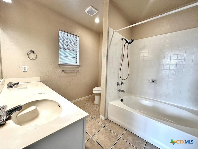 full bathroom featuring tile patterned floors, tiled shower / bath, vanity, and toilet