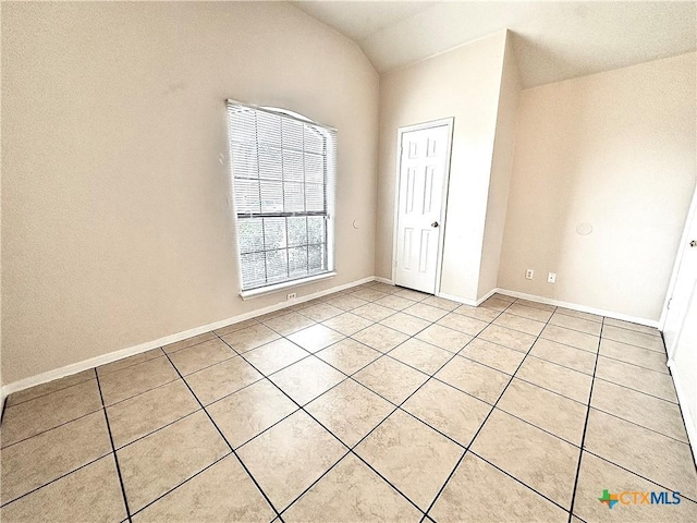 unfurnished bedroom featuring lofted ceiling and light tile patterned floors