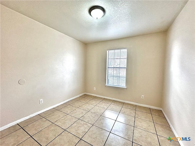 unfurnished room featuring light tile patterned floors and a textured ceiling