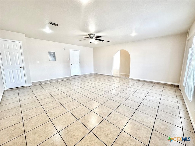 empty room featuring light tile patterned floors, a textured ceiling, electric panel, and ceiling fan