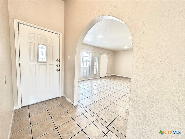 tiled foyer entrance with a textured ceiling