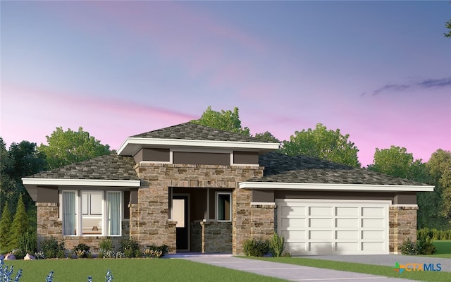 prairie-style home featuring an attached garage, stone siding, and a front yard