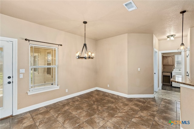 unfurnished dining area with washer / dryer and a chandelier