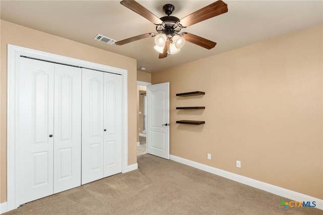 unfurnished bedroom featuring light colored carpet, a closet, and ceiling fan