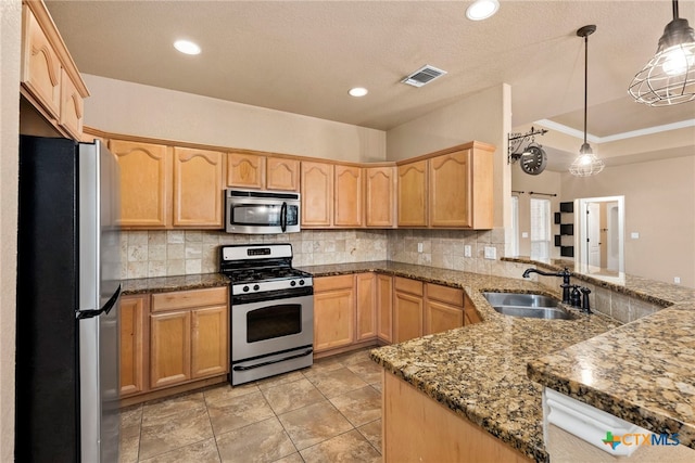 kitchen featuring appliances with stainless steel finishes, sink, backsplash, hanging light fixtures, and kitchen peninsula