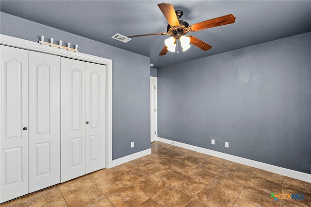 unfurnished bedroom featuring ceiling fan and a closet