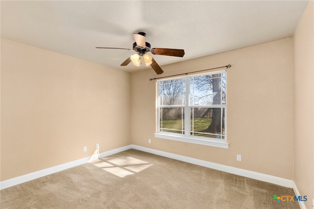 carpeted spare room with ceiling fan