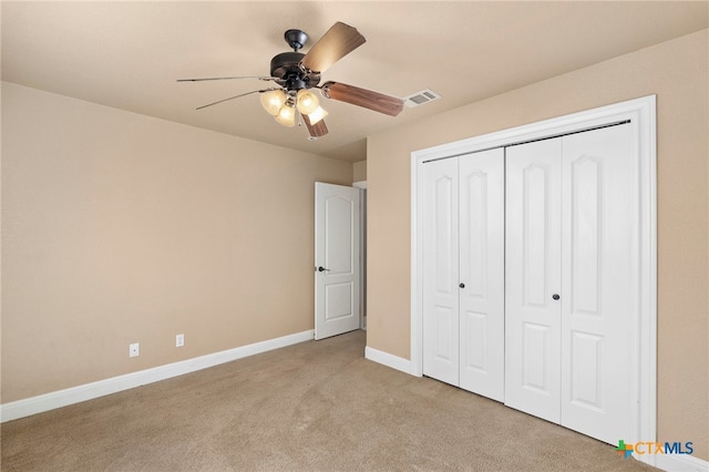 unfurnished bedroom featuring ceiling fan, a closet, and light carpet