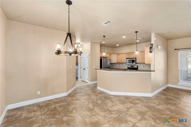 kitchen with appliances with stainless steel finishes, light brown cabinetry, decorative backsplash, hanging light fixtures, and kitchen peninsula