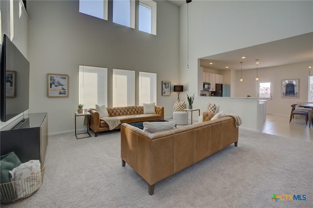 carpeted living room featuring a towering ceiling