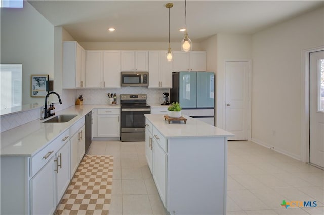 kitchen featuring hanging light fixtures, sink, white cabinets, and stainless steel appliances