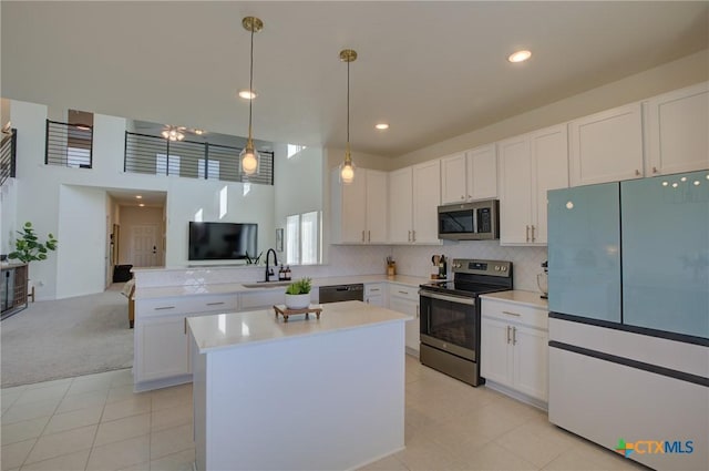 kitchen with white cabinets, hanging light fixtures, sink, light tile patterned floors, and appliances with stainless steel finishes