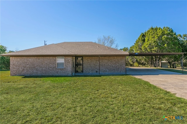 rear view of house featuring a carport and a yard