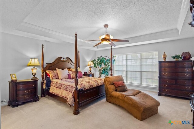 carpeted bedroom with a textured ceiling, a raised ceiling, and crown molding