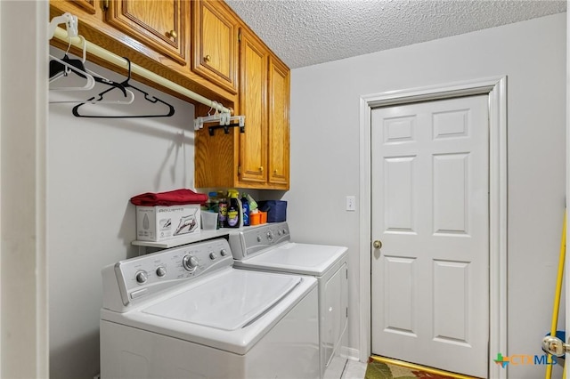 washroom featuring washing machine and dryer, a textured ceiling, and cabinet space