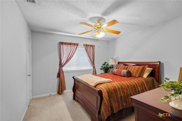 bedroom with light carpet, baseboards, a textured ceiling, and ceiling fan
