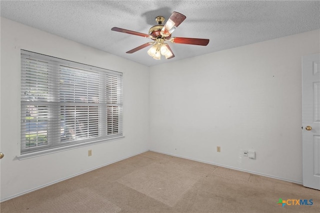 unfurnished room with a textured ceiling, ceiling fan, a healthy amount of sunlight, and light carpet