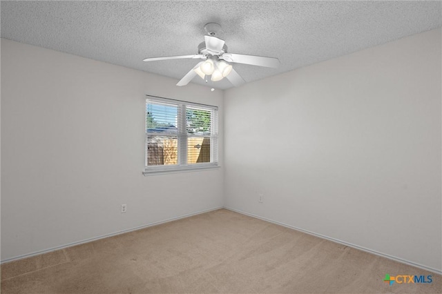 empty room with a ceiling fan, a textured ceiling, and light carpet