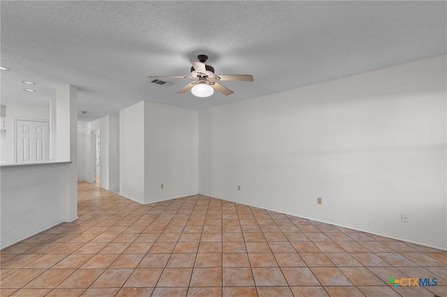 spare room featuring visible vents, a ceiling fan, a textured ceiling, and light tile patterned floors