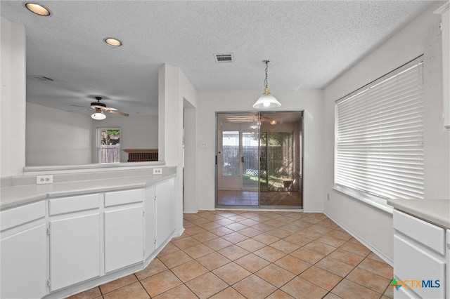 interior space featuring visible vents, a textured ceiling, ceiling fan, and light tile patterned floors