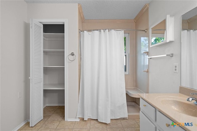 bathroom featuring a closet, vanity, a shower with curtain, and a textured ceiling