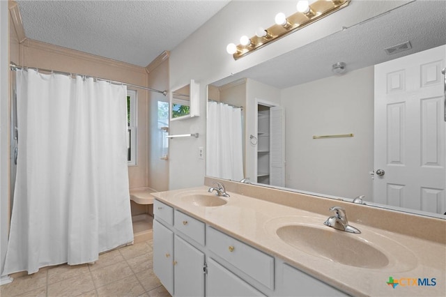 full bathroom with a sink, double vanity, a textured ceiling, and visible vents