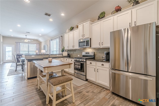 kitchen with ceiling fan, white cabinets, light hardwood / wood-style floors, and appliances with stainless steel finishes