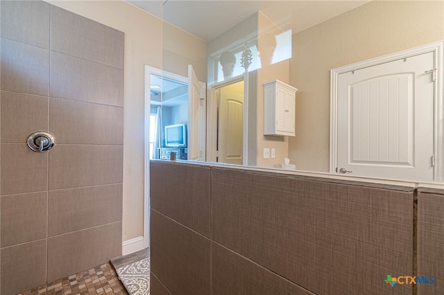 bathroom with tile patterned flooring, tile walls, and walk in shower