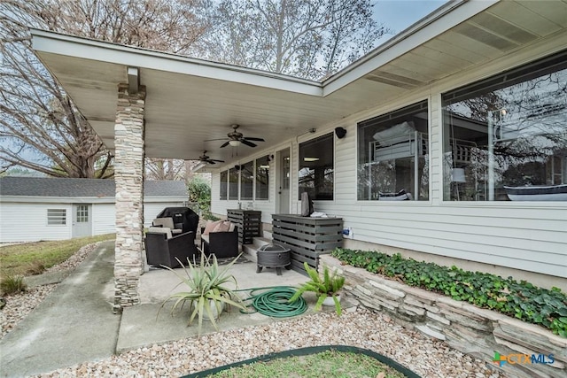 view of patio / terrace with ceiling fan and an outdoor living space with a fire pit