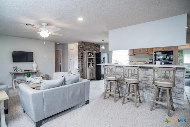 living room with ceiling fan and a textured ceiling