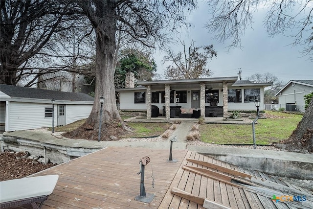 back of property featuring central AC unit and a lawn