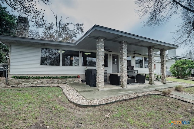 rear view of house featuring an outdoor living space, a lawn, ceiling fan, and a patio area