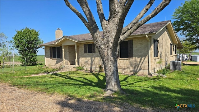 ranch-style home with central AC, a chimney, a front lawn, and brick siding