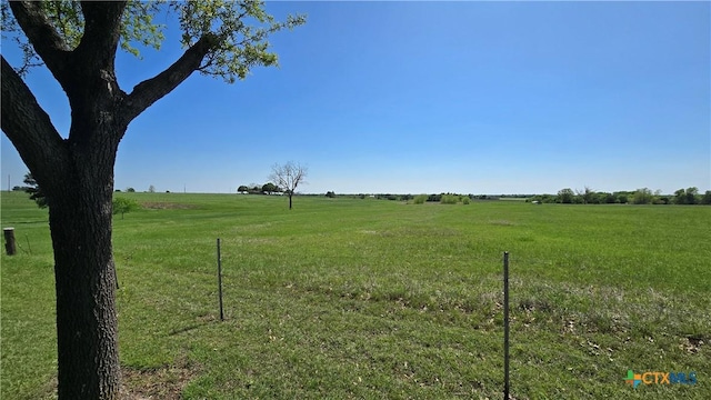 view of yard with a rural view and fence