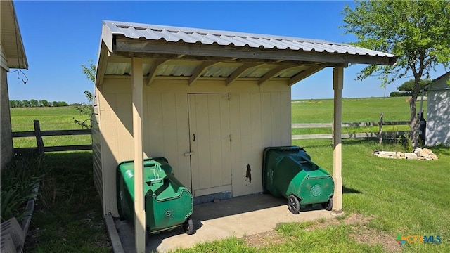 view of shed with fence and a rural view