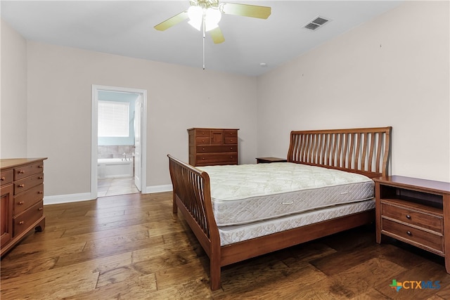 bedroom featuring ensuite bath, dark hardwood / wood-style floors, and ceiling fan