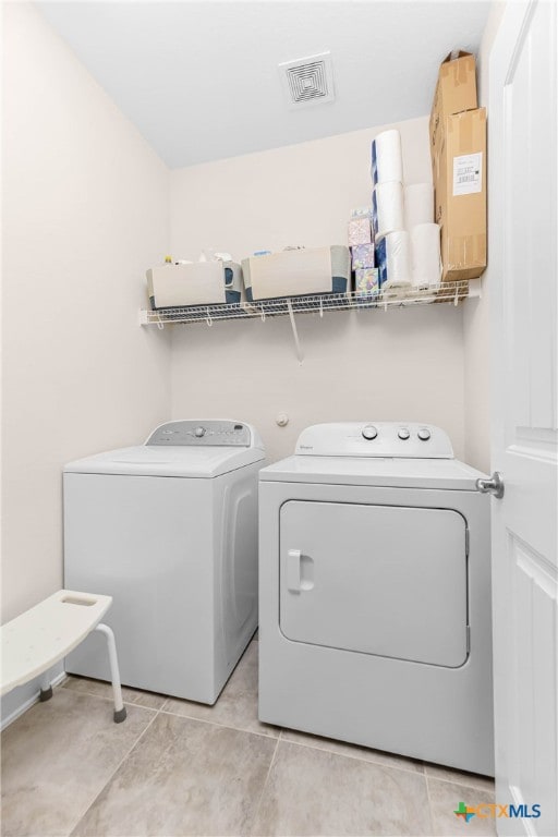 laundry area featuring light tile patterned floors and separate washer and dryer