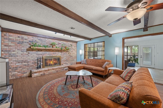 3909 Alderwood Ln, Temple, TX 76502 - living area featuring wood finished floors, a textured ceiling, beamed ceiling, ceiling fan, and a fireplace
