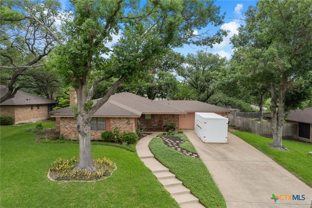 3909 Alderwood Ln, Temple, TX 76502 - mid-century modern home with concrete driveway, roof with shingles, and brick siding