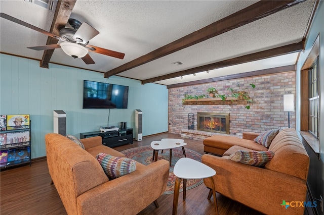 3909 Alderwood Ln, Temple, TX 76502 - living room featuring wood finished floors, a textured ceiling, a fireplace, ceiling fan, and beam ceiling
