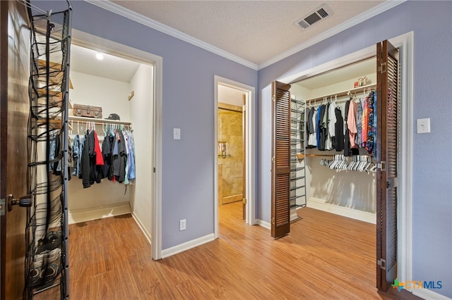 3909 Alderwood Ln, Temple, TX 76502 - bedroom featuring a closet, wood finished floors, ornamental molding, a walk in closet, and baseboards