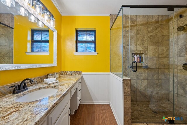 3909 Alderwood Ln, Temple, TX 76502 - full bath with wood finished floors, a stall shower, ornamental molding, vanity, and wainscoting