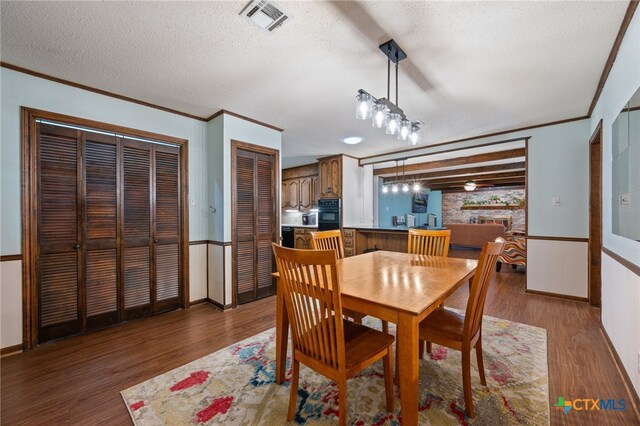 3909 Alderwood Ln, Temple, TX 76502 - dining area featuring crown molding, wood finished floors, a textured ceiling, and baseboards