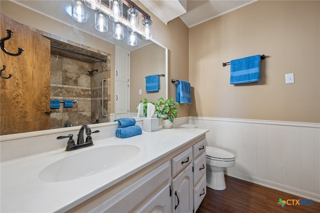 3909 Alderwood Ln, Temple, TX 76502 - bathroom with a tile shower, vanity, toilet, wood finished floors, and a wainscoted wall