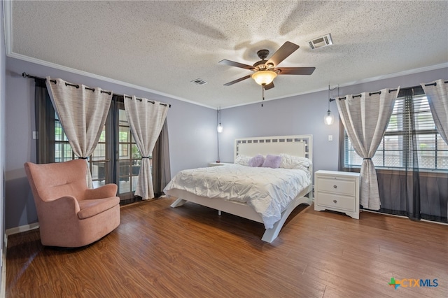 3909 Alderwood Ln, Temple, TX 76502 - bedroom featuring wood finished floors, multiple windows, a textured ceiling, crown molding, and ceiling fan
