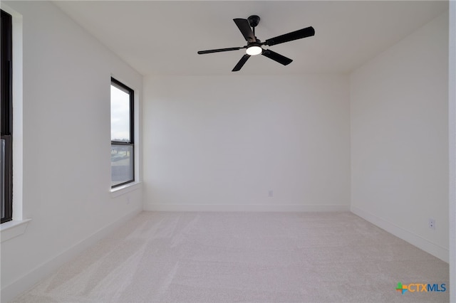 unfurnished room with baseboards, ceiling fan, and light carpet