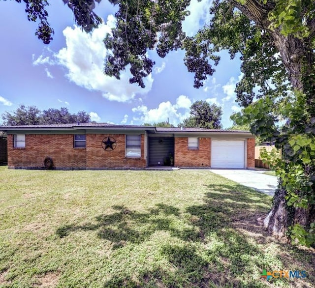 3207 Linda Dr, Victoria, TX 77901 - ranch-style house featuring brick siding, an attached garage, concrete driveway, and a front lawn